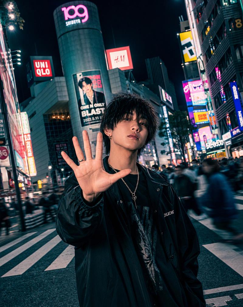 Young person in Tokyo at night throwing a hand turkey